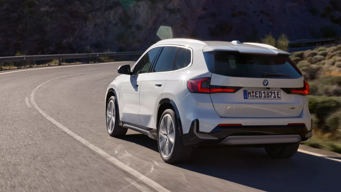 Vue avant du BMW iX1 électrique sur route de campagne